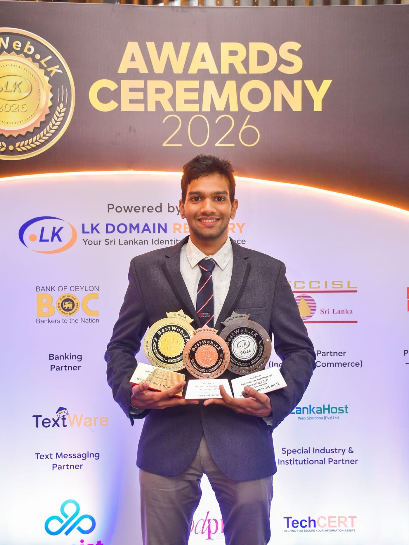 Agzaiyenth Ganaraj holding three BestWeb.lk 2026 trophies at the awards ceremony